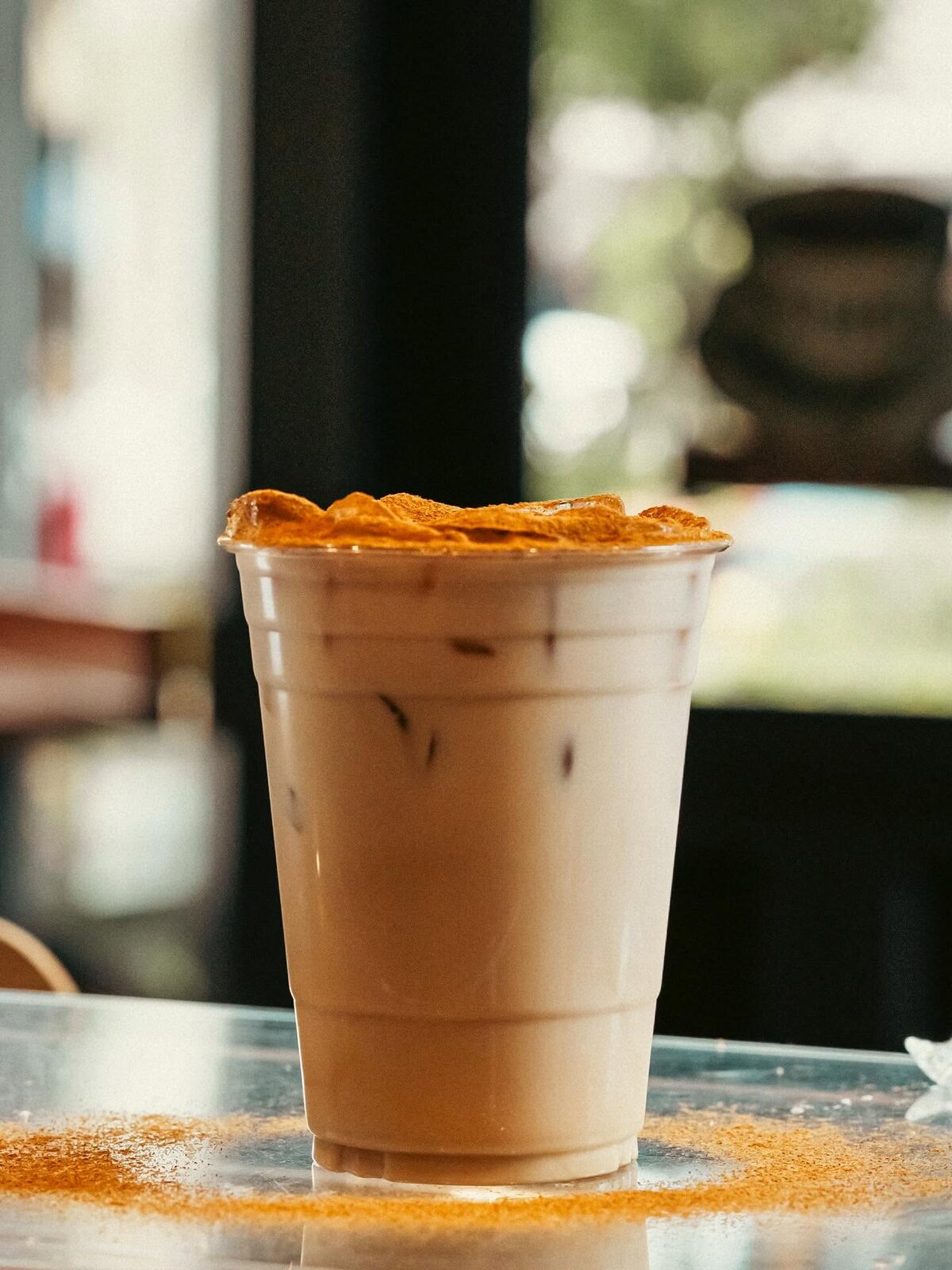 Iced latte dusted with cinnamon on the counter