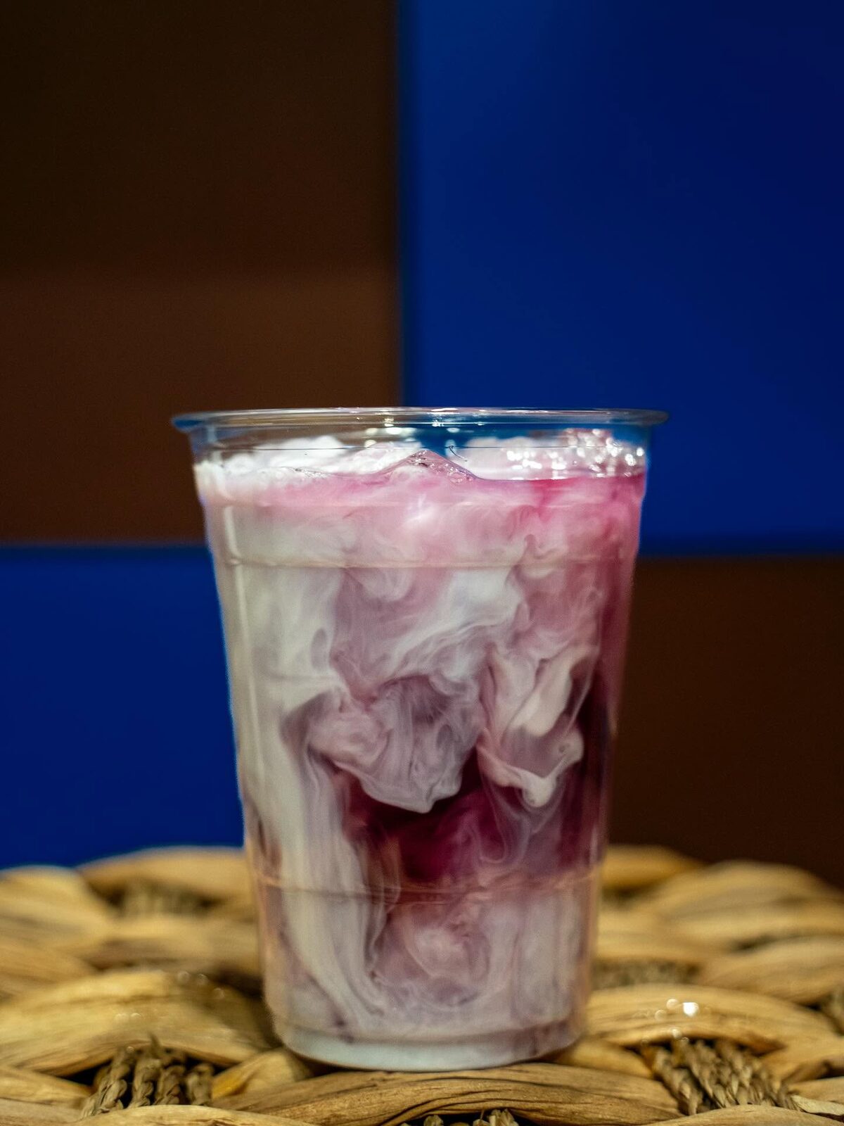 Iced drink with a swirl of berry-colored syrup and milk