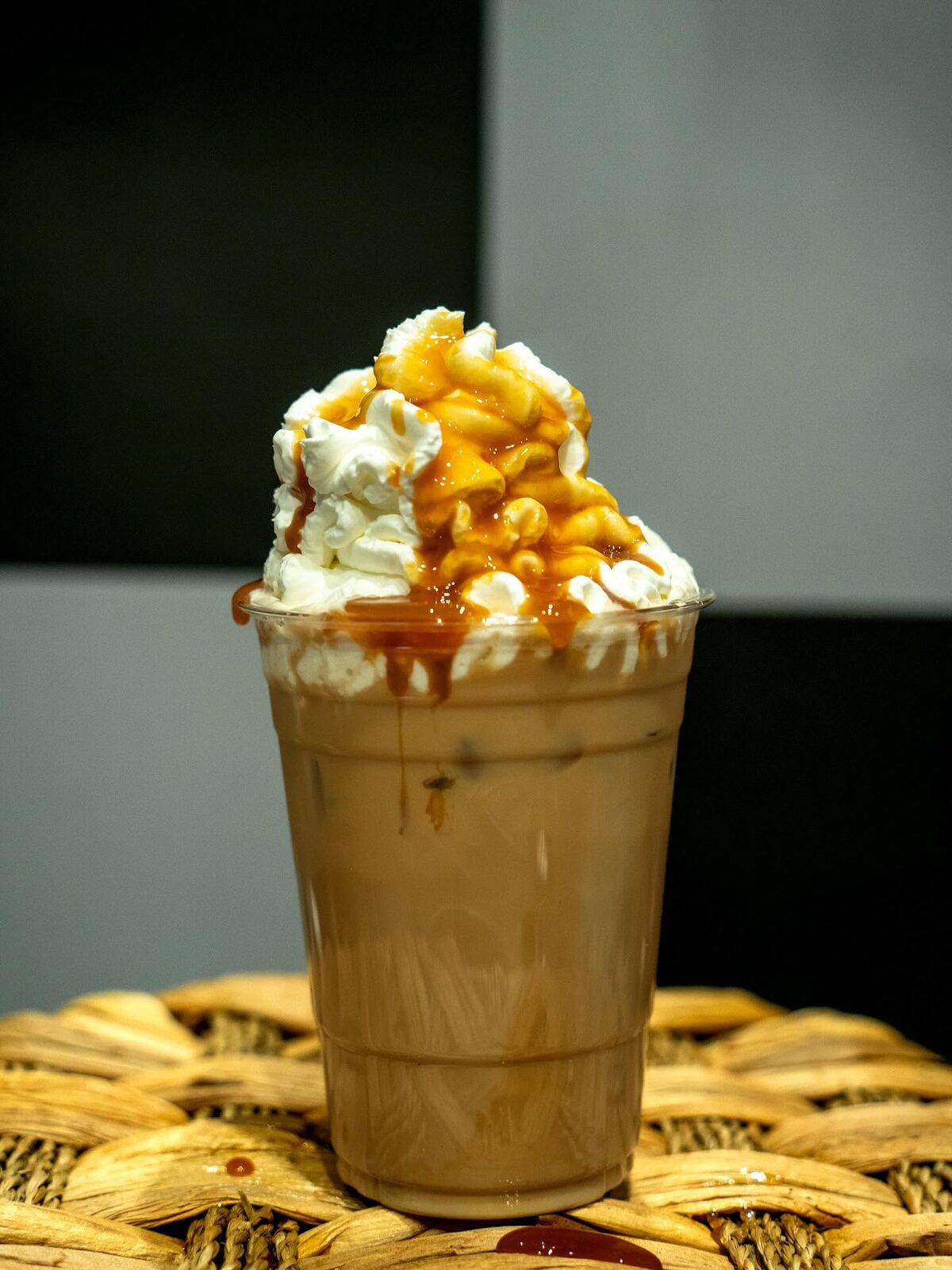 Iced drink topped with whipped cream and caramel drizzle