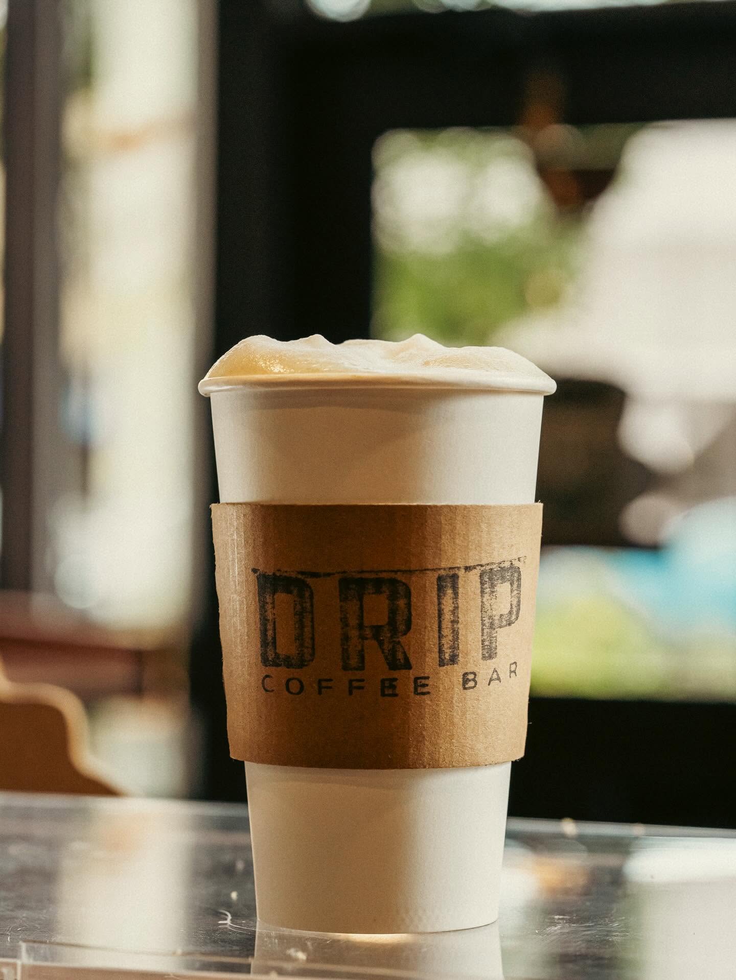 Takeaway cup with the Drip Coffee Bar logo